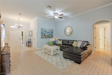 Living room with ornamental molding and ceiling fa