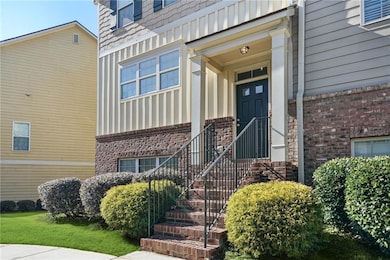 Property entrance featuring board and batten siding and brick siding