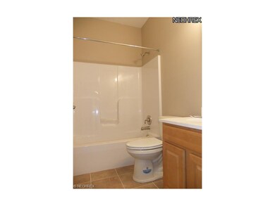 The guest bathroom features tile floor, white tub 
