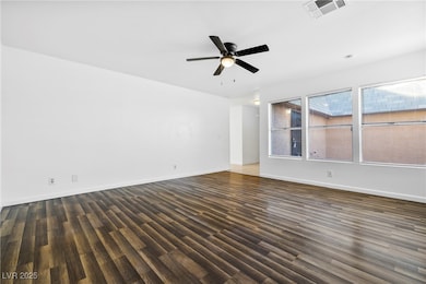 Spare room featuring dark wood finished floors and ceiling fan