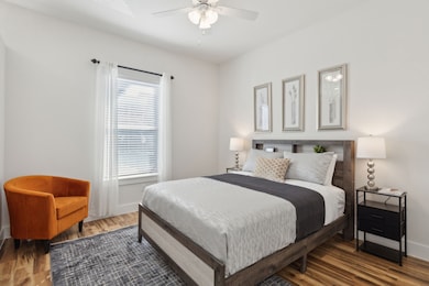 Bedroom featuring wood finished floors and a ceiling fan