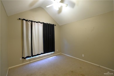 Carpeted empty room with lofted ceiling and ceiling fan