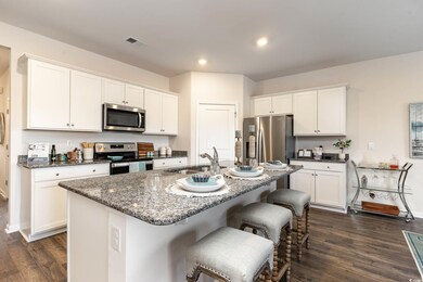 Kitchen featuring baseboards, visible vents, dark 