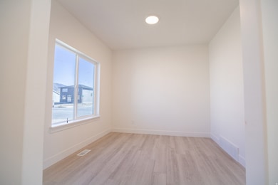 Living room with large window and laminate flooring.