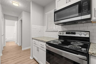 Kitchen with light wood-type flooring, baseboards,