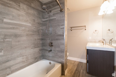 Full bathroom featuring bathtub / shower combination, vanity, and wood finished floors