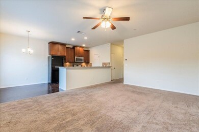 Unfurnished living room with a ceiling fan, carpe