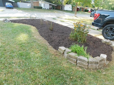 View of green lawn with driveway