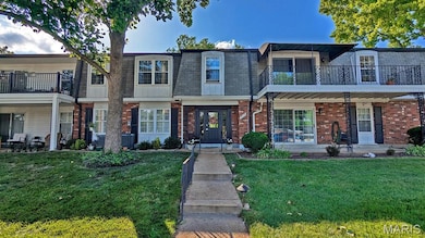 View of front of home featuring a balcony, a front lawn, brick siding, mansard roof, and a shingled roof