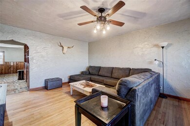 Living area with arched walkways, ceiling fan, lig