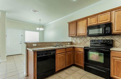 Kitchen featuring a sink, a peninsula, black appli