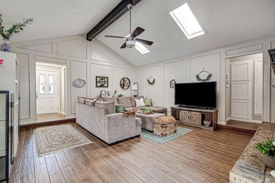Living room with vaulted ceiling with skylight, wo
