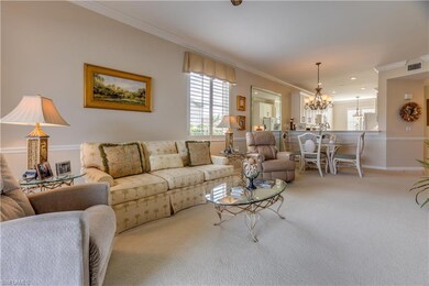 Carpeted living room with a notable chandelier and