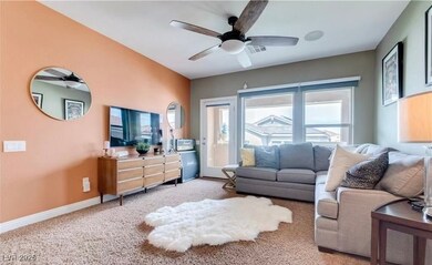Carpeted living room featuring ceiling fan and bas