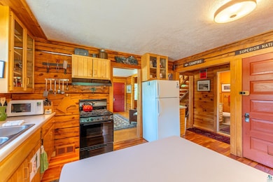 Kitchen with wooden walls, hardwood / wood-style f