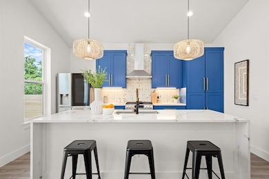 Kitchen featuring wall chimney range hood, blue c