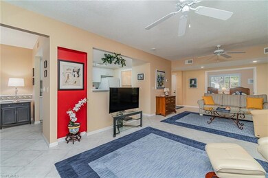 Living room featuring two ceiling fans and light tile patterned floors