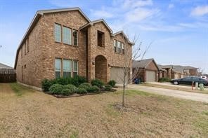 View of front of property with concrete driveway, a garage, and brick siding