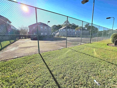 View of tennis court featuring a lawn