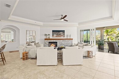 Living area with a tray ceiling, visible vents, pl