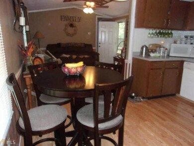 Dining room with light wood-type flooring, ceiling fan, and crown molding