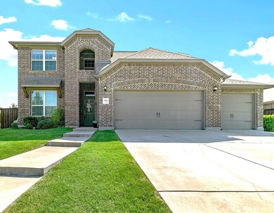 View of front of house featuring a front lawn and a garage