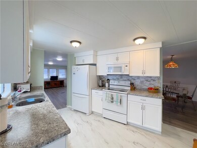 Kitchen with white appliances, white cabinets, dec