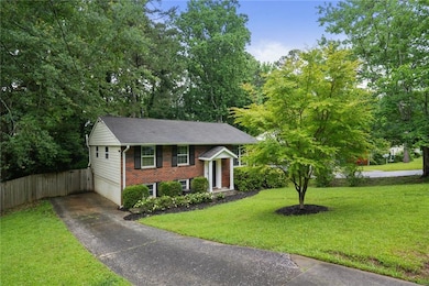 Raised ranch featuring driveway, brick siding, and an attached garage