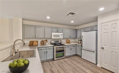 Kitchen featuring a sink, white appliances, light