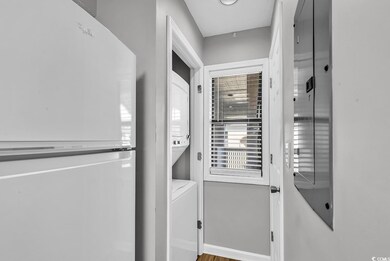 Laundry room with stacked washer and clothes dryer