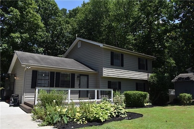 Tri-level home featuring covered porch and a front lawn