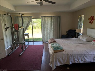 Bedroom with access to exterior, wood finished floors, and ceiling fan
