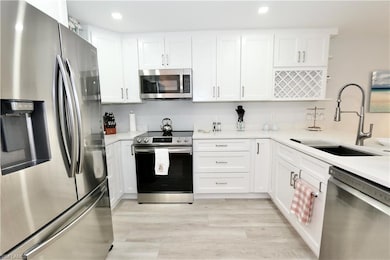 Kitchen with light countertops, appliances with st