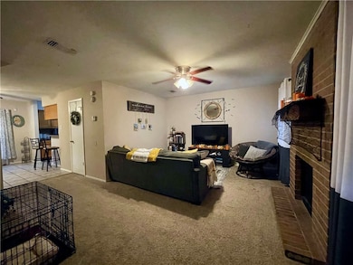 Living room featuring ceiling fan, a fireplace, an