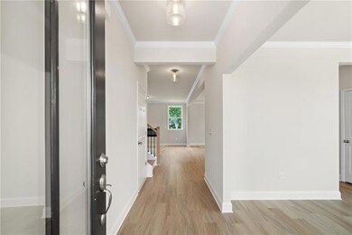 Corridor with light wood-type flooring, baseboards, and ornamental molding