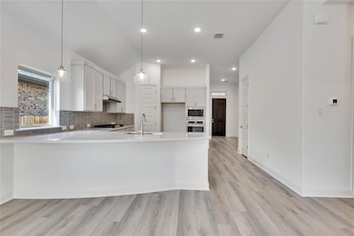 Kitchen featuring a peninsula, tasteful backsplas