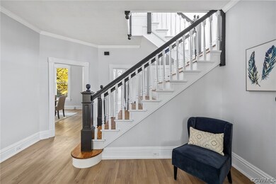 Staircase with ornamental molding and light hardwood / wood-style floors