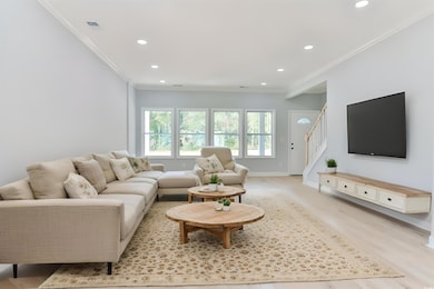 Living room with crown molding and light hardwood / wood-style flooring