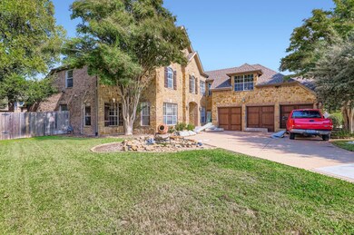 Traditional-style home featuring driveway, a garage, stone siding, and brick siding