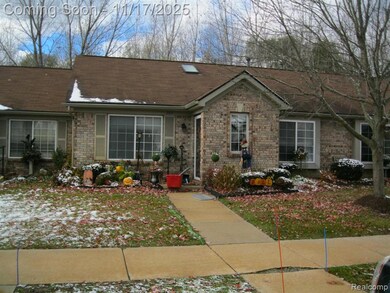 View of front facade with brick siding and a shingled roof