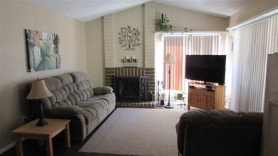 Living room showing fireplace and vaulted ceiling.