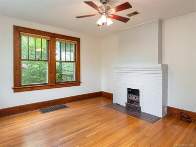 Period fireplace and beautiful original flooring in the master bedroom.