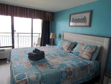 Bedroom with a textured ceiling and access to outside