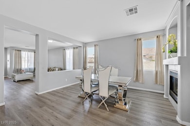 Dining space with light wood-type flooring and a fireplace