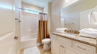 Full bathroom with vanity, shower / tub combo, til