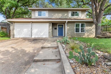 Traditional home with stone siding, driveway, and