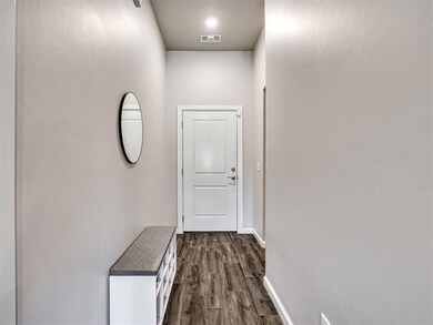 Hallway featuring visible vents, baseboards, and d