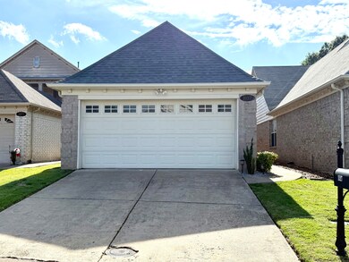 View of front of property with concrete driveway, a shingled roof, a garage, and a front yard