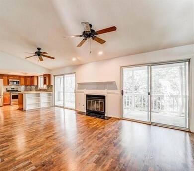Unfurnished living room featuring lofted ceiling, light wood-type flooring, a fireplace with flush hearth, ceiling fan, and recessed lighting