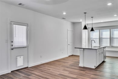 Kitchen with dark wood-style floors, visible vents